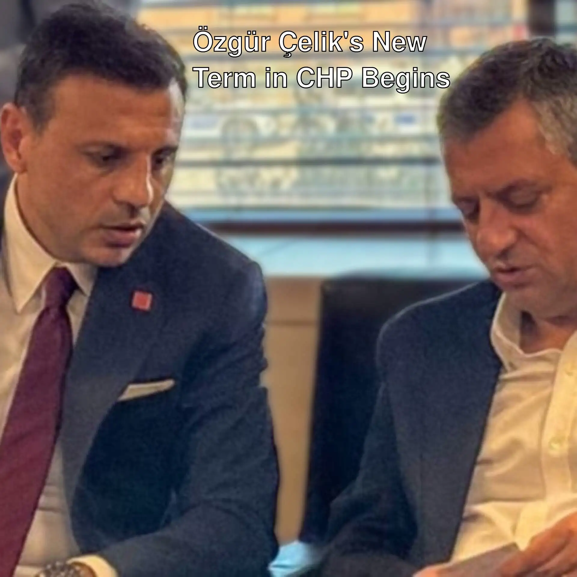 Two men in suits looking at something.