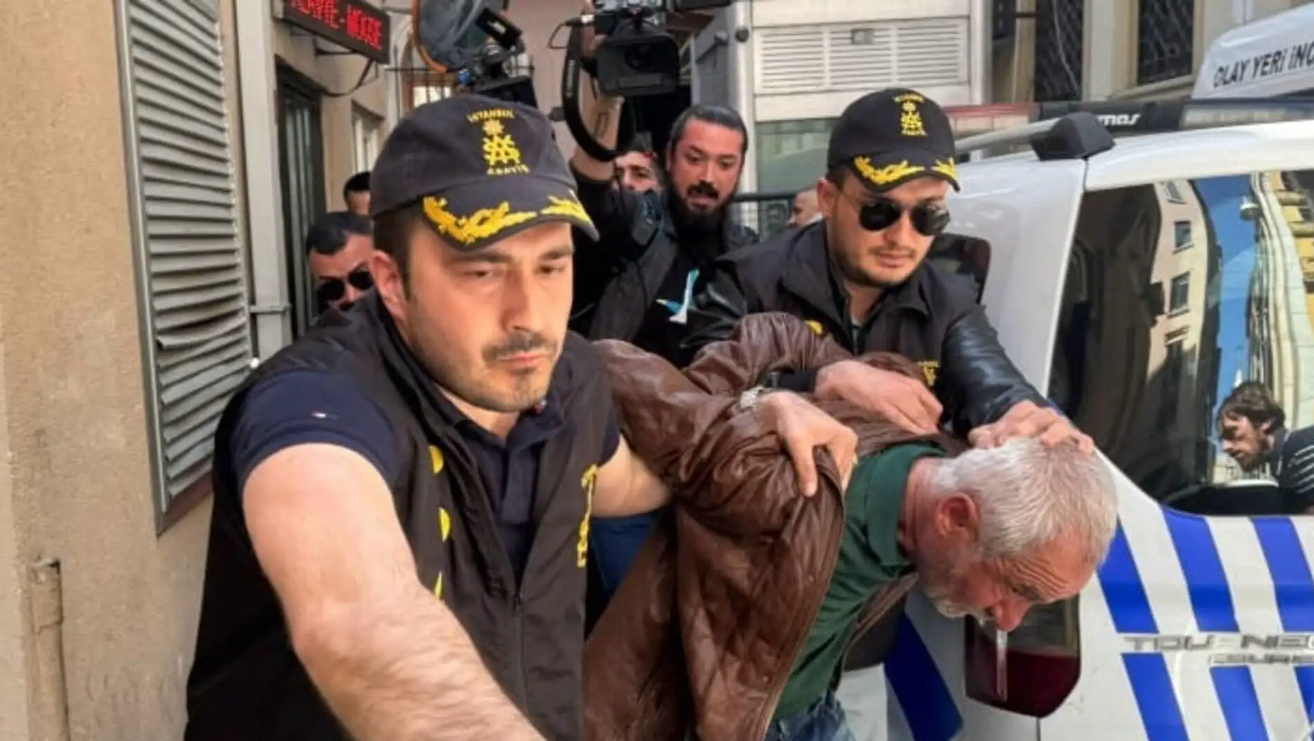 Selçuk Tengioğlu being taken away by police officers.