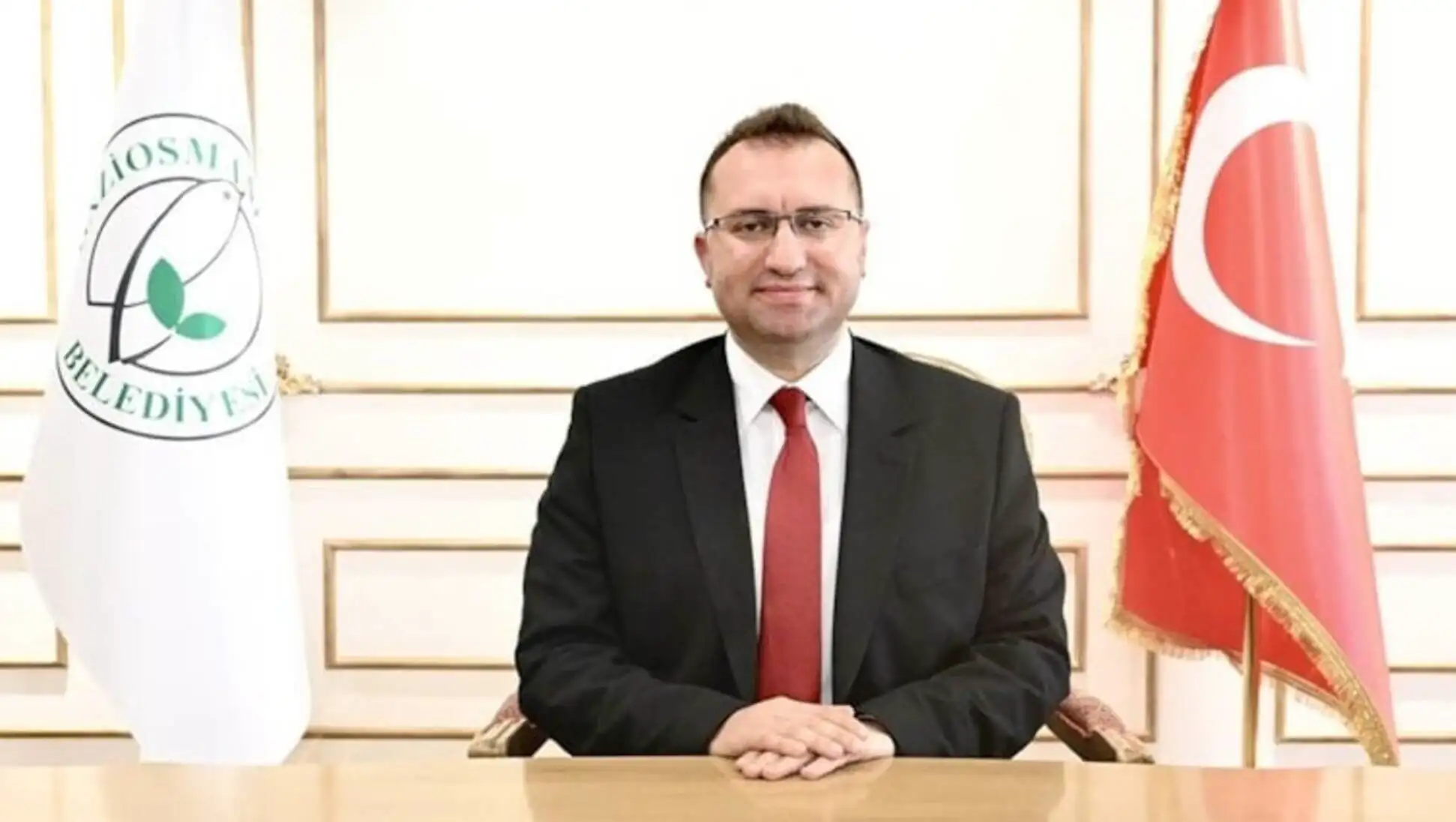 Bir adam takım elbise giymiş ve kravat takmış.