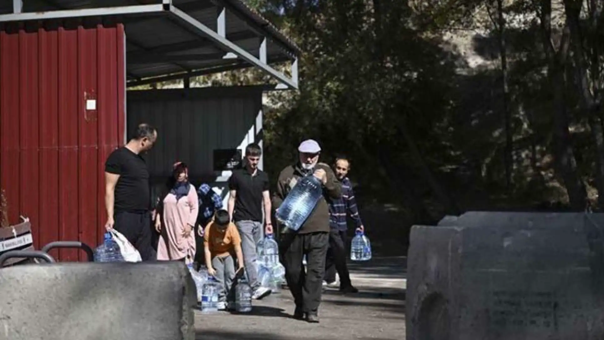 A group of people carrying water bottles.