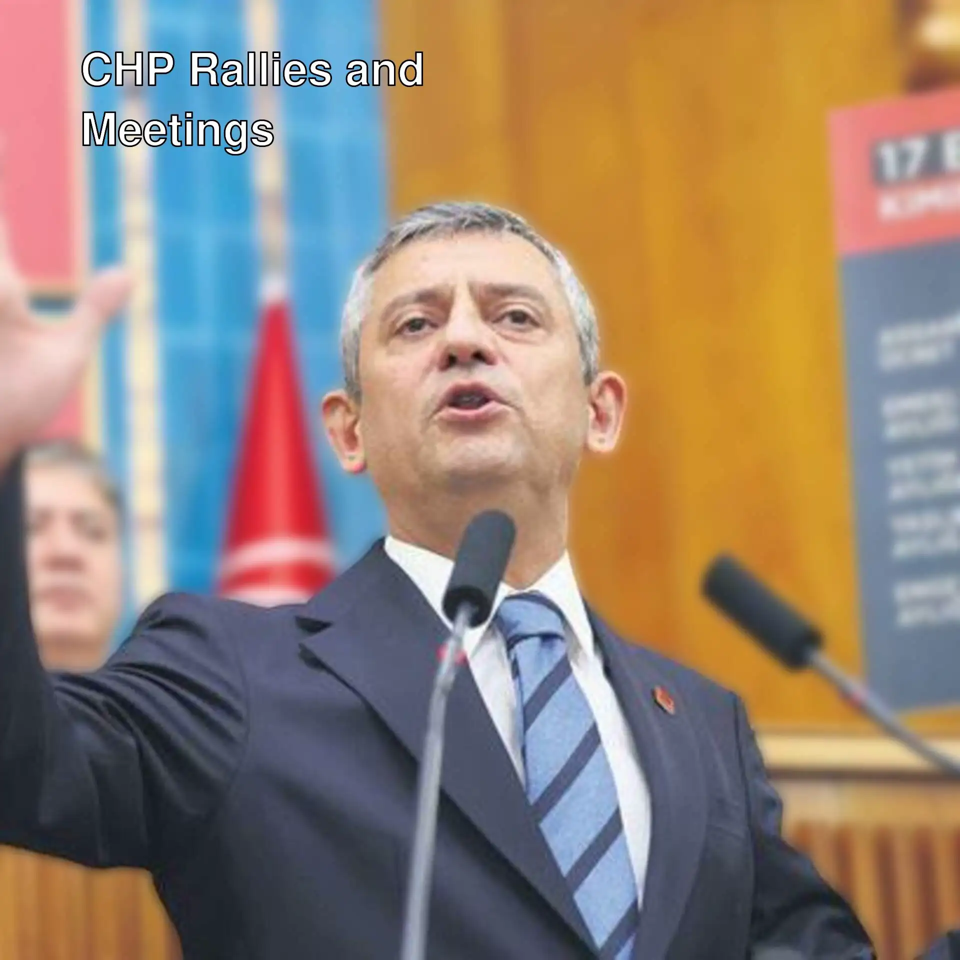 A man in a suit standing in front of microphones.
