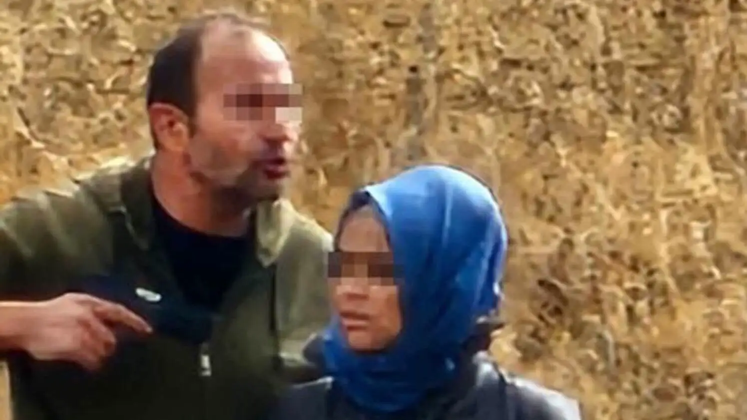 Bir adam, bir kadının yüzüne işaret ediyor.