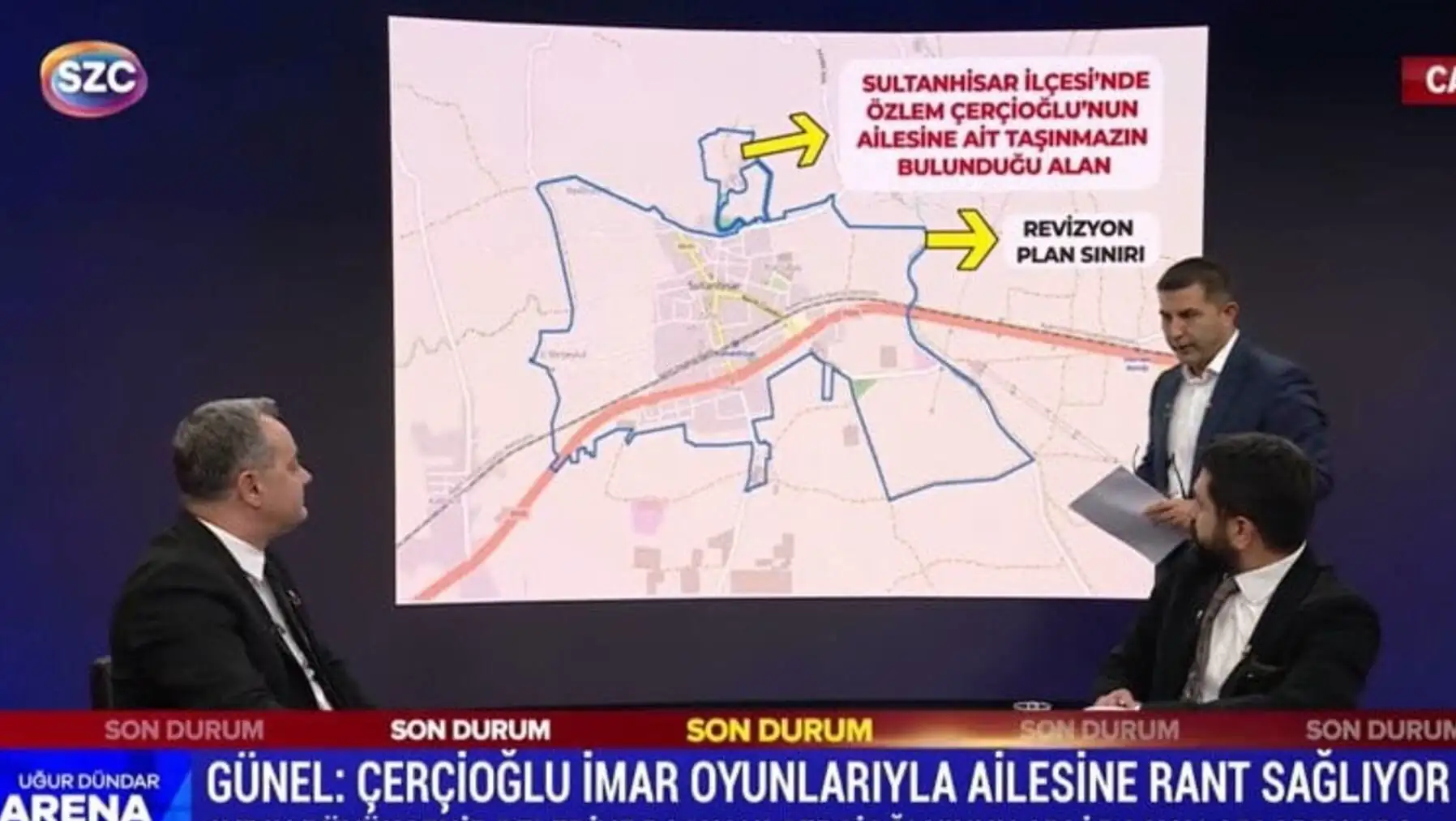 Bir adam büyük bir ekranın önünde duruyor.