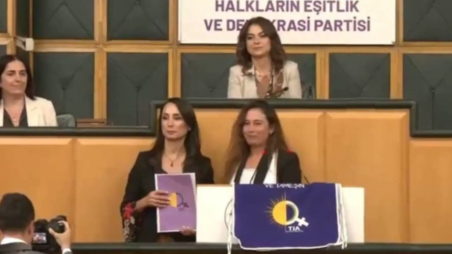 A group of women sitting at a podium. A group of women sitting at a podium.