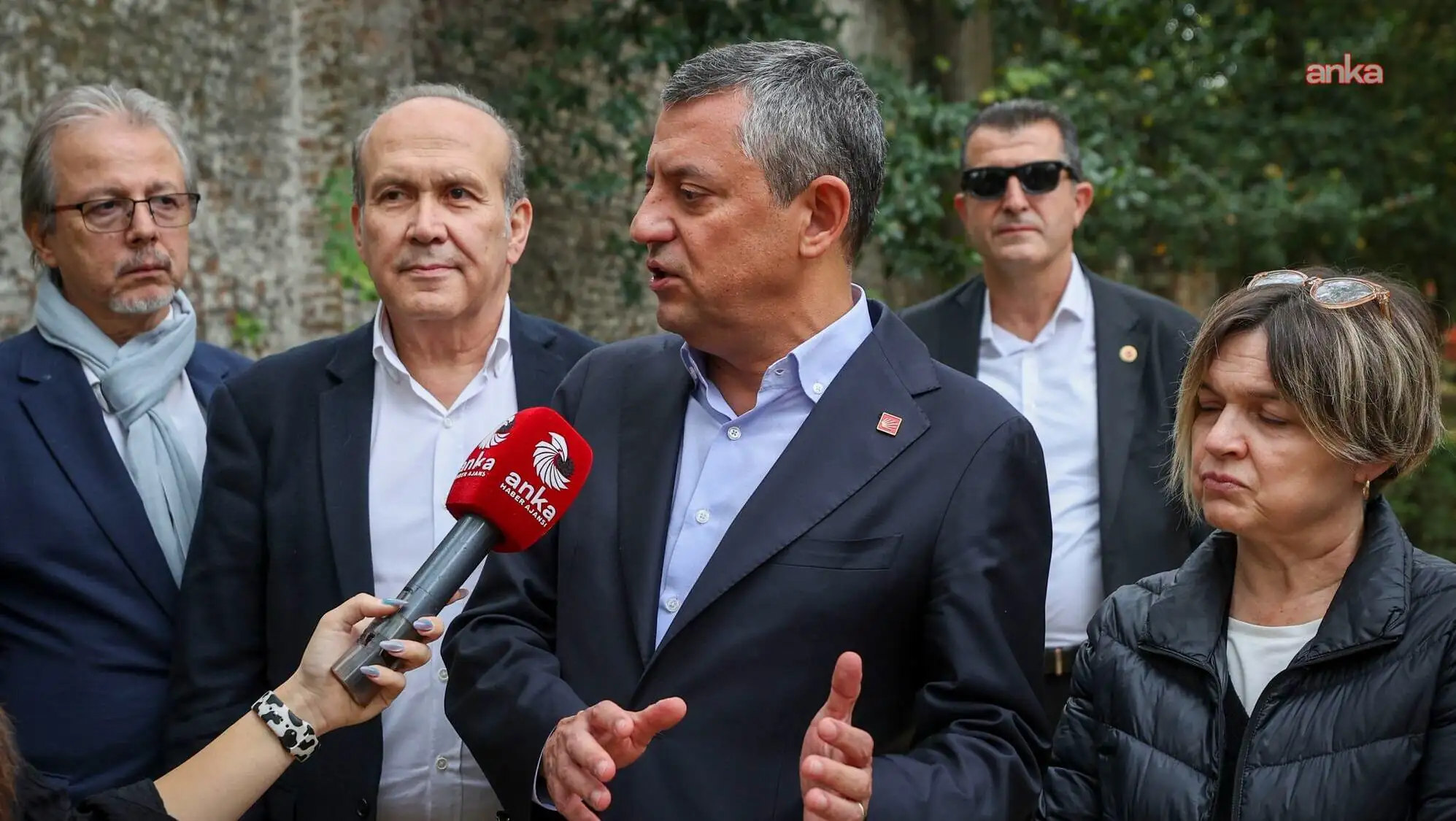 Özgür Özel talking to a woman with a microphone.