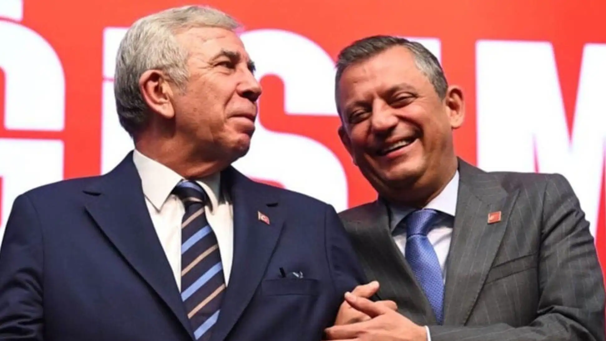 Özgür Özel smiling with another man.
