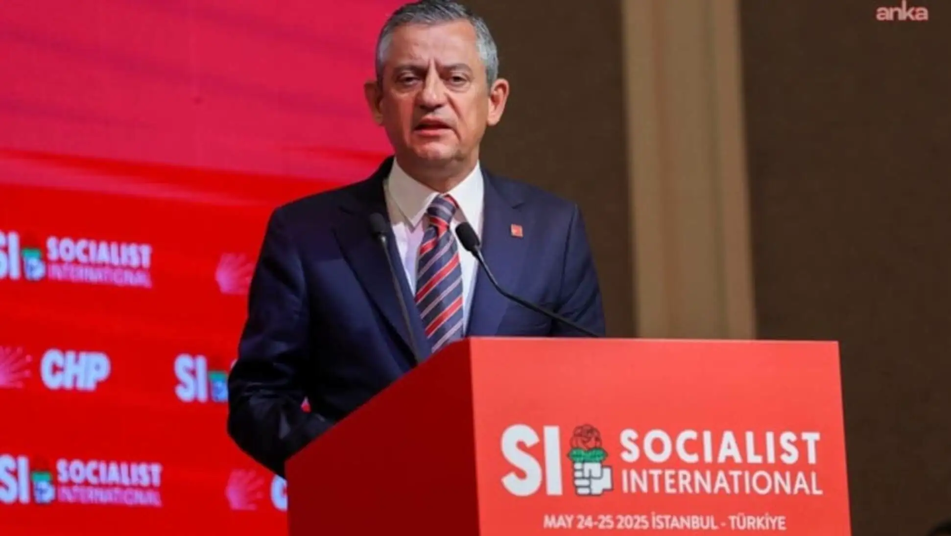 Özgür Özel, bir podiumda duruyor.