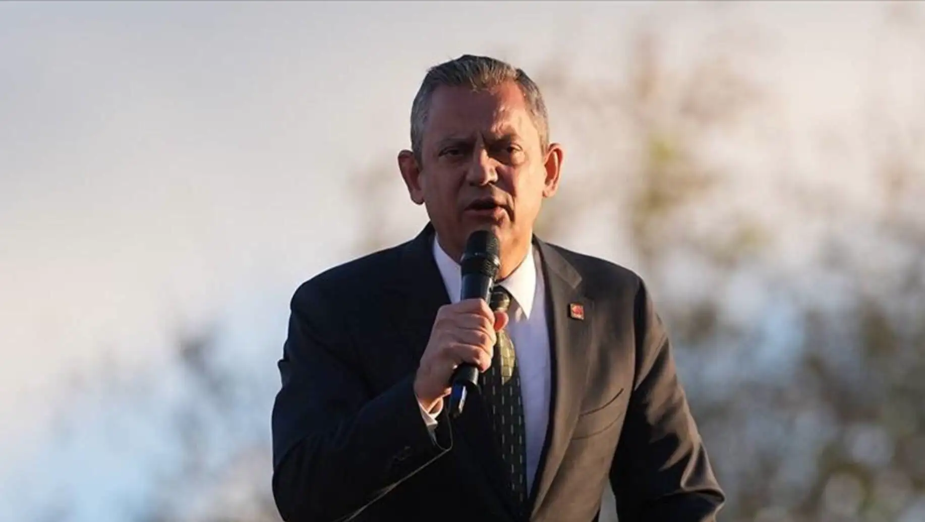 Özgür Özel speaking into a microphone. Özgür Özel speaking into a microphone.