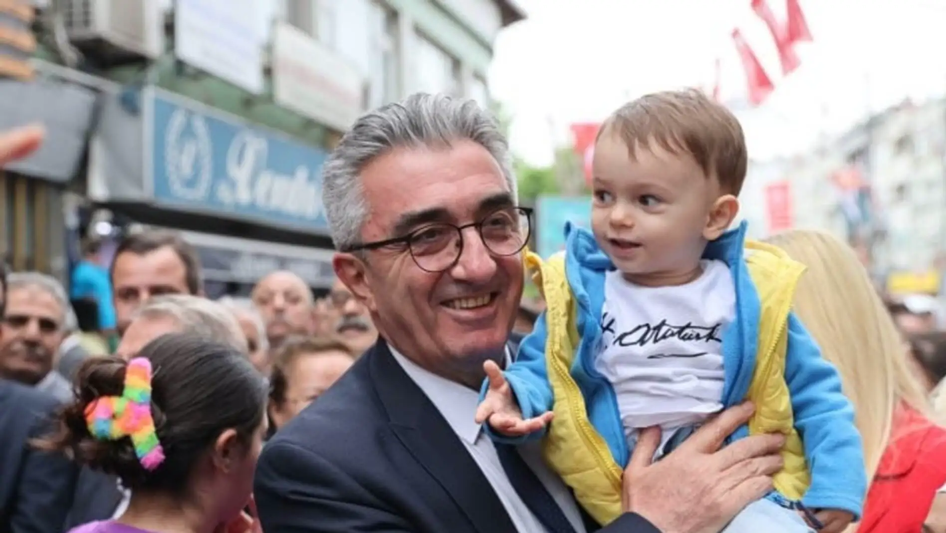 Hasan Mutlu holding a baby.