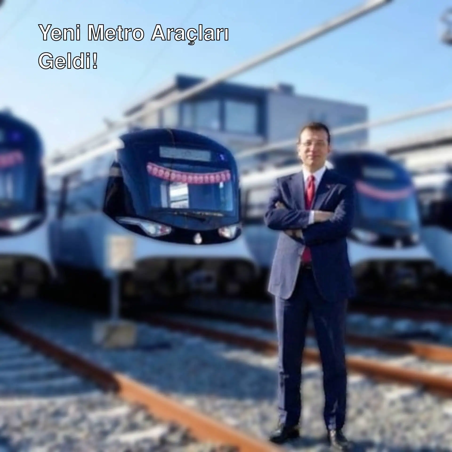 Ekrem İmamoğlu, yeni metro araçlarının önünde duruyor.